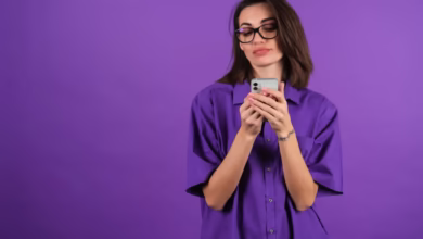 Mulher segurando celular, representando transferência de dinheiro do Nubank sem tarifas