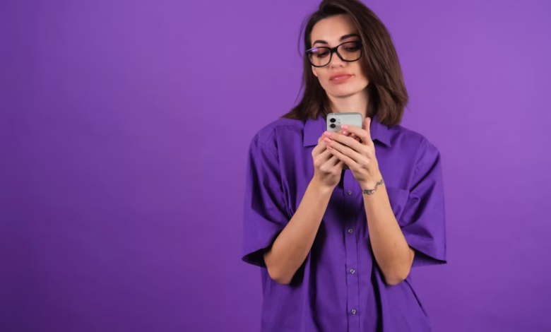 Mulher segurando celular, representando transferência de dinheiro do Nubank sem tarifas