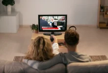Casal assistindo a notícias na TV sobre a oficialização da TV 3.0.