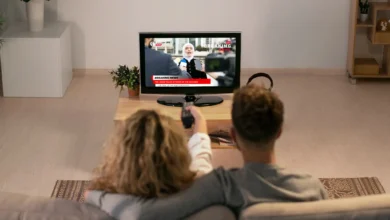 Casal assistindo a notícias na TV sobre a oficialização da TV 3.0.