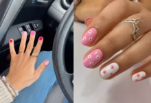 Unhas curtas decoradas com tons de rosa e detalhes florais.
