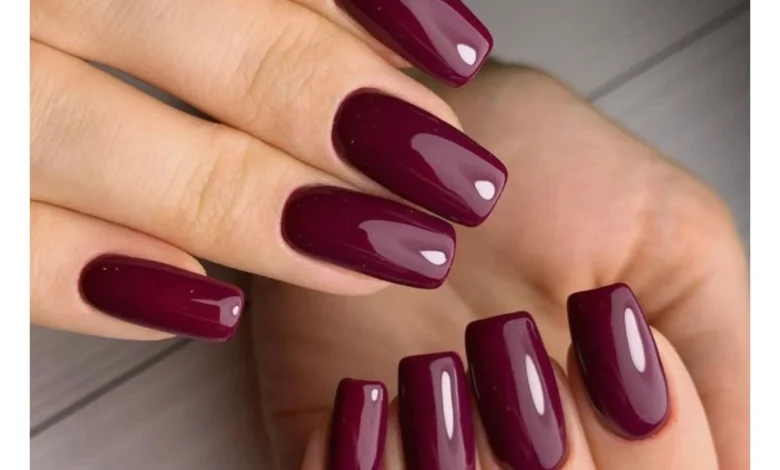 Unhas com esmalte vinho escuro glossy, proporcionando um acabamento brilhante e sofisticado.