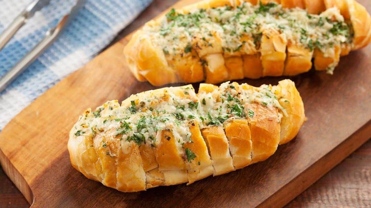 Pão de alho recheado com queijo e ervas frescas, pronto para servir.