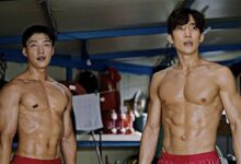 Os atores Woo Do-hwan e Lee Sang-yi, sem camisa, mostrando o físico musculoso em uma cena de treinamento de boxe do dorama ‘Cães de Caça’.