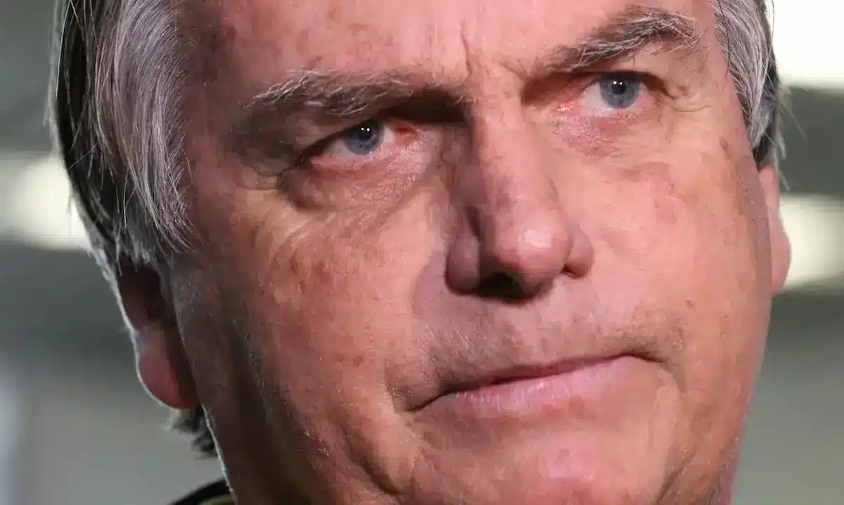 Imagem de Jair Bolsonaro com expressão séria, destacando-se pela questão de sua condenação e possível prisão.