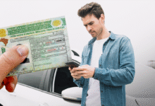 Homem consulta o celular enquanto uma Carteira Nacional de Habilitação é mostrada em primeiro plano, representando o acesso fácil à CNH e a economia que os brasileiros podem ter com o novo processo de habilitação.