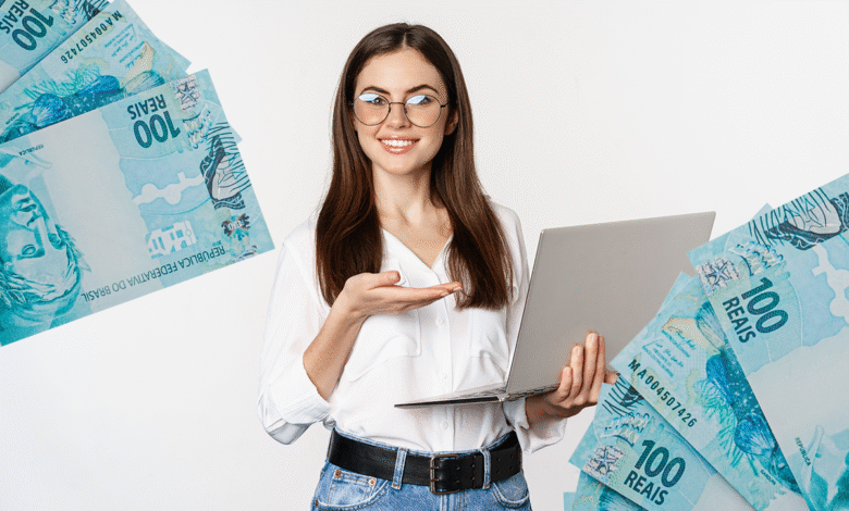 Mulher sorrindo segura notebook com notas de 100 reais ao redor, simbolizando ganho financeiro ou dinheiro virtual.
