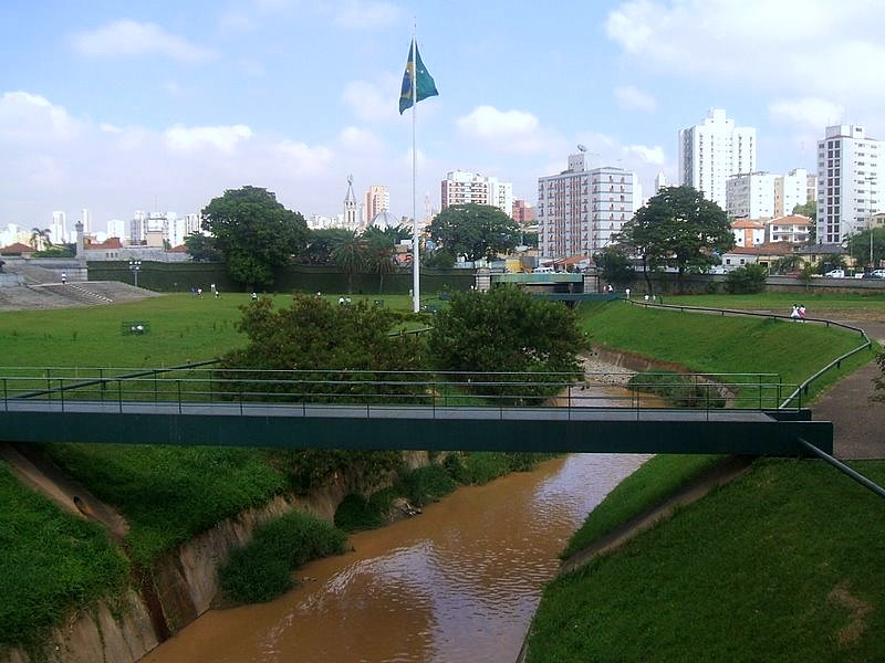 Vista atual do Riacho do Ipiranga, com uma ponte sobre ele e a paisagem urbana ao fundo.