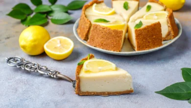 Deliciosa torta de limão com base de biscoito, decorada com raspas de limão e chantilly.