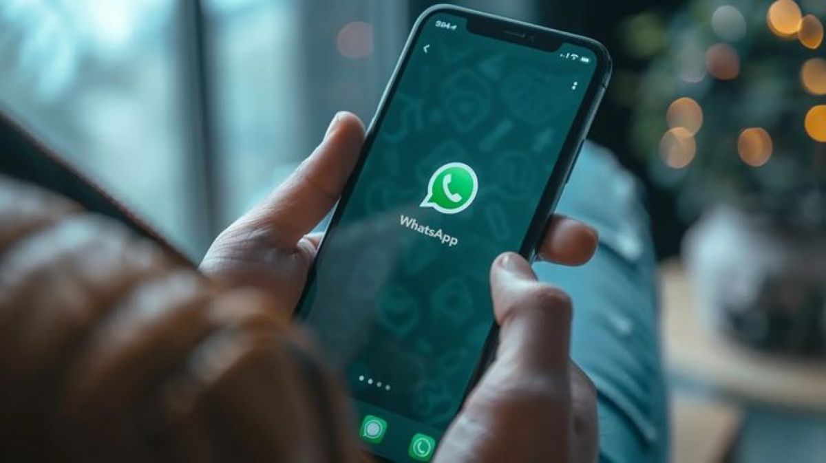 Mãos segurando um celular com o ícone do WhatsApp, representando as novas atualizações previstas para 2025