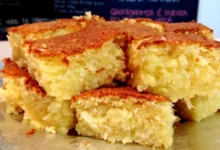 Bolo de mandioca de liquidificador cortado em pedaços, com textura macia e dourada.