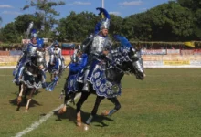 Cavalhada de Pirenópolis, com cavaleiros em armaduras coloridas e adornos brilhantes, em desfile durante a festa popular de Goiás.