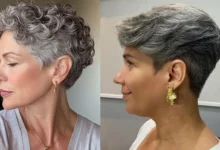 Mulher com cabelo curto estilo pixie, com fios cacheados e grisalhos, mostrando um corte moderno e elegante.