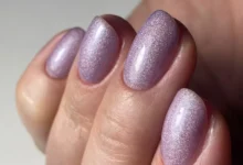 Unhas com esmalte lilás holográfico, mostrando o brilho cintilante da cor da moda no verão europeu