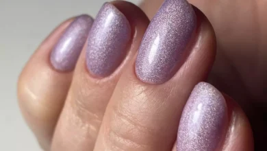 Unhas com esmalte lilás holográfico, mostrando o brilho cintilante da cor da moda no verão europeu