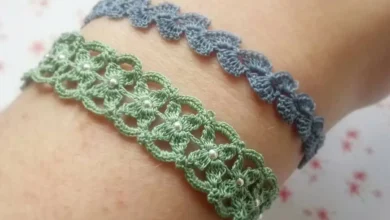 O par de pulseiras de crochê, uma verde com detalhes em pérolas e a outra azul, exibindo a delicadeza e o estilo dos acessórios feitos à mão