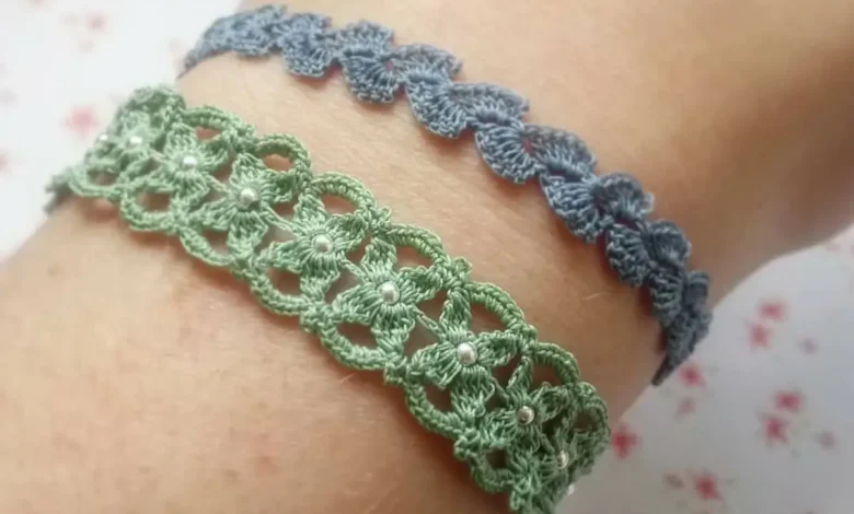 O par de pulseiras de crochê, uma verde com detalhes em pérolas e a outra azul, exibindo a delicadeza e o estilo dos acessórios feitos à mão