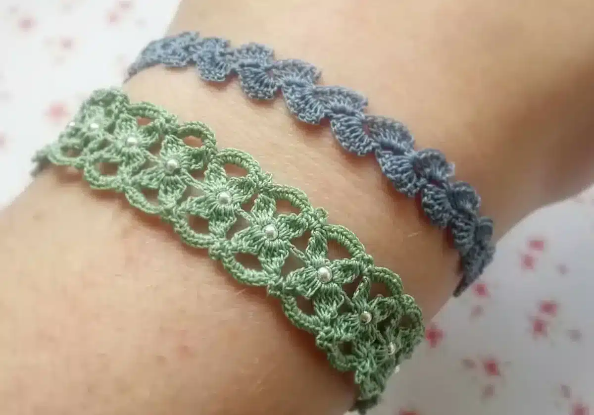 O par de pulseiras de crochê, uma verde com detalhes em pérolas e a outra azul, exibindo a delicadeza e o estilo dos acessórios feitos à mão