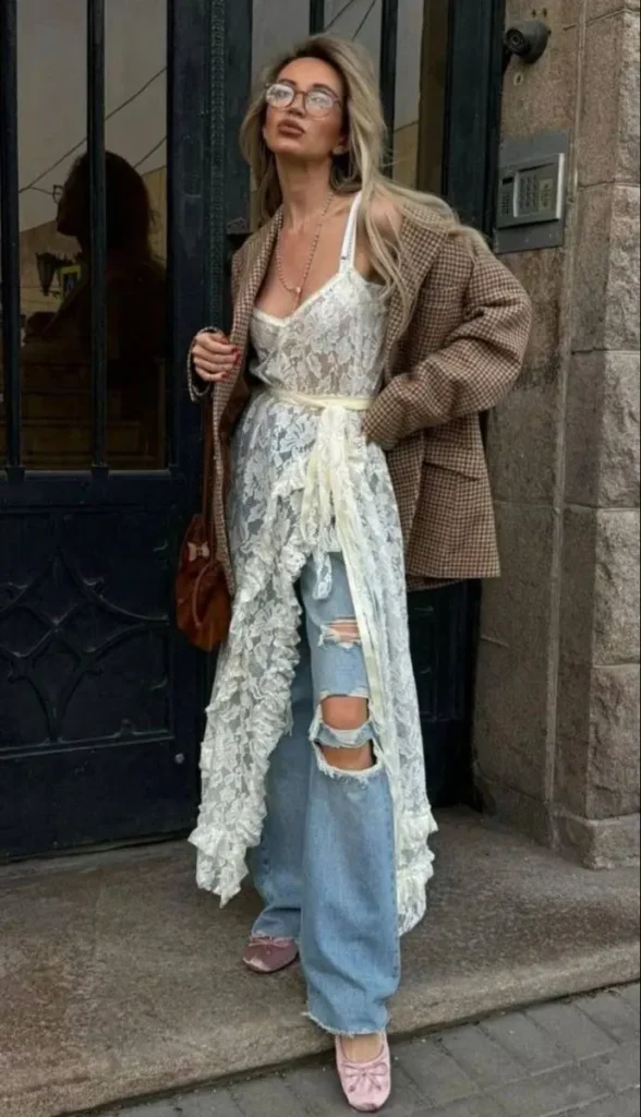Look criativo com vestido de renda sobre calça jeans rasgada e sapatos rosados.