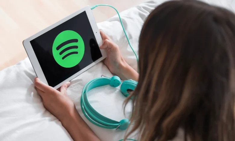 Imagem mostrando logo do Spotify em tablet, com fones de ouvido, ilustrando as novidades para usuários gratuitos.