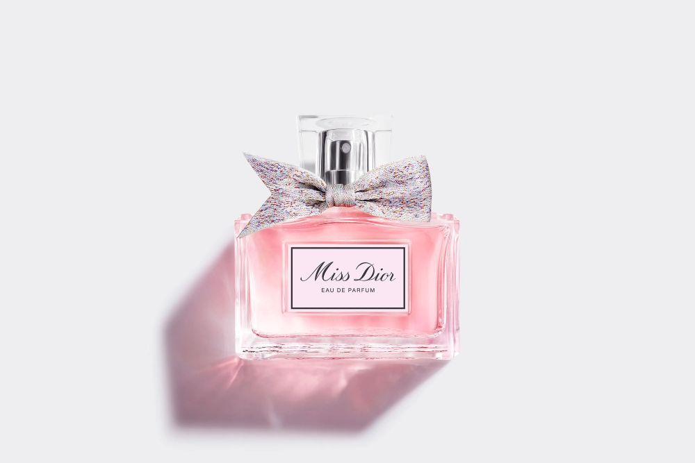  Frasco do perfume Miss Dior Eau de Parfum, na cor rosa suave com um laço delicado, representando a elegância das fragrâncias florais para a primavera.