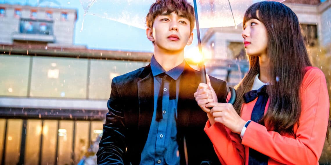 Casal de dorama de comédia romântica sob um guarda-chuva em uma noite chuvosa, representando o romance com toques de fantasia da série "Eu Não Sou um Robô".