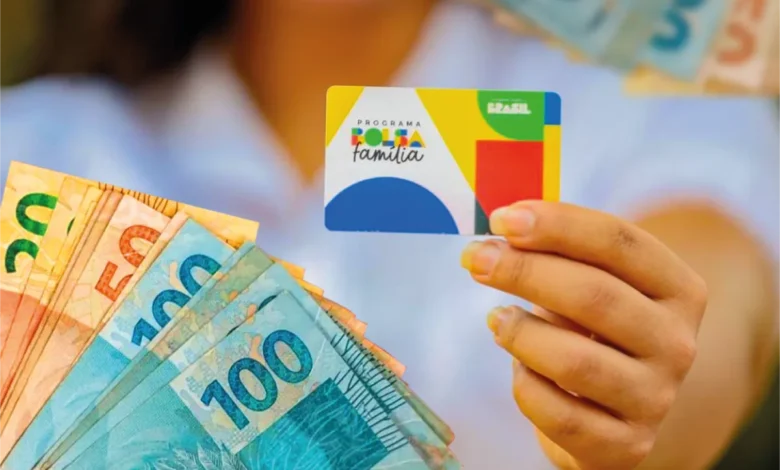 Cartão do programa Bolsa Família com cédulas de dinheiro, ilustrando o novo calendário de pagamentos do programa em outubro.