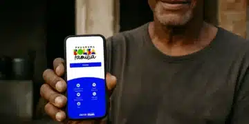 Homem mostrando celular com tela do Programa Bolsa Família Brasil com opções de acesso e informações