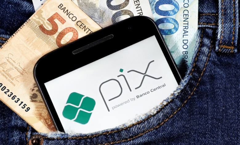 Celular com logo do PIX no bolso de calça junto a notas de real.