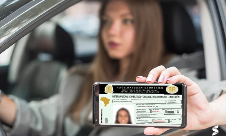 Pessoa mostrando sua CNH digital no celular enquanto está dentro de um carro, ilustrando a digitalização do processo de habilitação no Brasil.