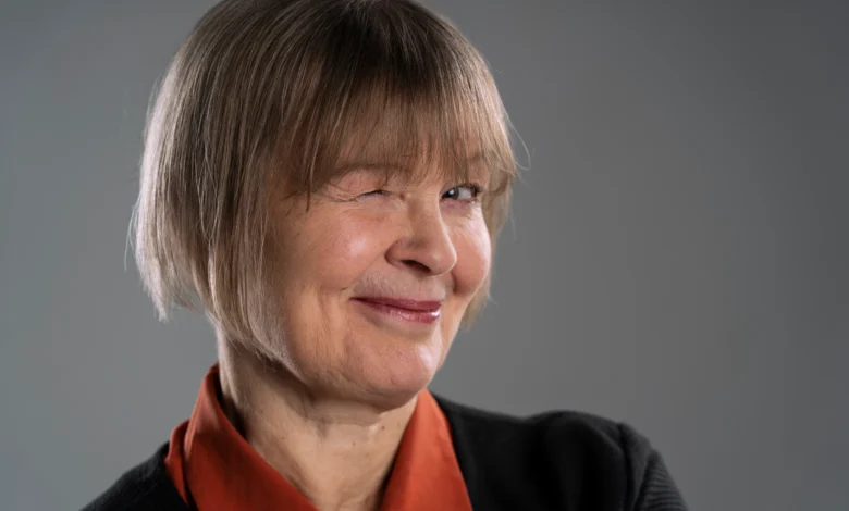 Mulher sorrindo e piscando, com cabelo curto e franja, representando a tendência do corte de cabelo para mulheres 50+.