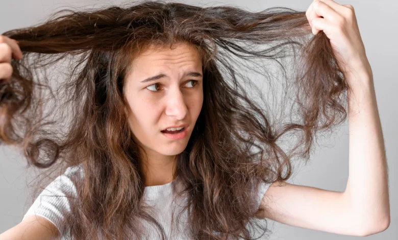 Mulher com cabelo danificado e armado, mostrando frustração ao tentar controlar os fios.