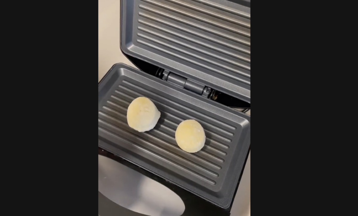 Pão de queijo na sanduicheira: etapa inicial da receita na sanduicheira, mostrando o queijo ainda não derretido.