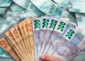 Notas de dinheiro brasileiras, incluindo valores de R$ 50, R$ 100 e R$ 200, representando a liberação de R$ 2.6 bilhões para aposentados do INSS.