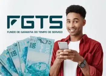 Homem sorridente segurando celular ao lado do logo FGTS e várias notas de 100 reais