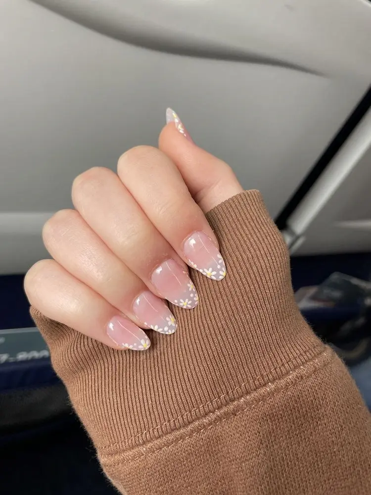 Unhas francesinha delicada com flores brancas na ponta.