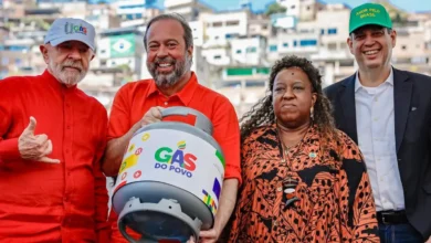 Quatro pessoas em evento político com botijão de gás do povo e roupas coloridas