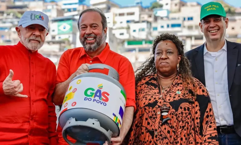 Quatro pessoas em evento político com botijão de gás do povo e roupas coloridas