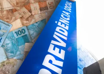 Notas de Reais com a placa da Previdência Social, representando a recuperação de valores e descontos indevidos pelo INSS.