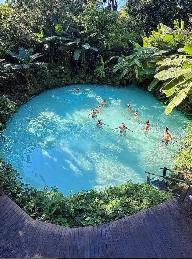 Jalapão, Tocantins, com turistas desfrutando da água cristalina em um cenário rodeado por vegetação exuberante.
