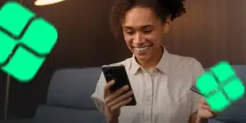 Pessoa sorrindo enquanto usa o celular para realizar uma transação com cartão, representando o uso do Pix parcelado.
