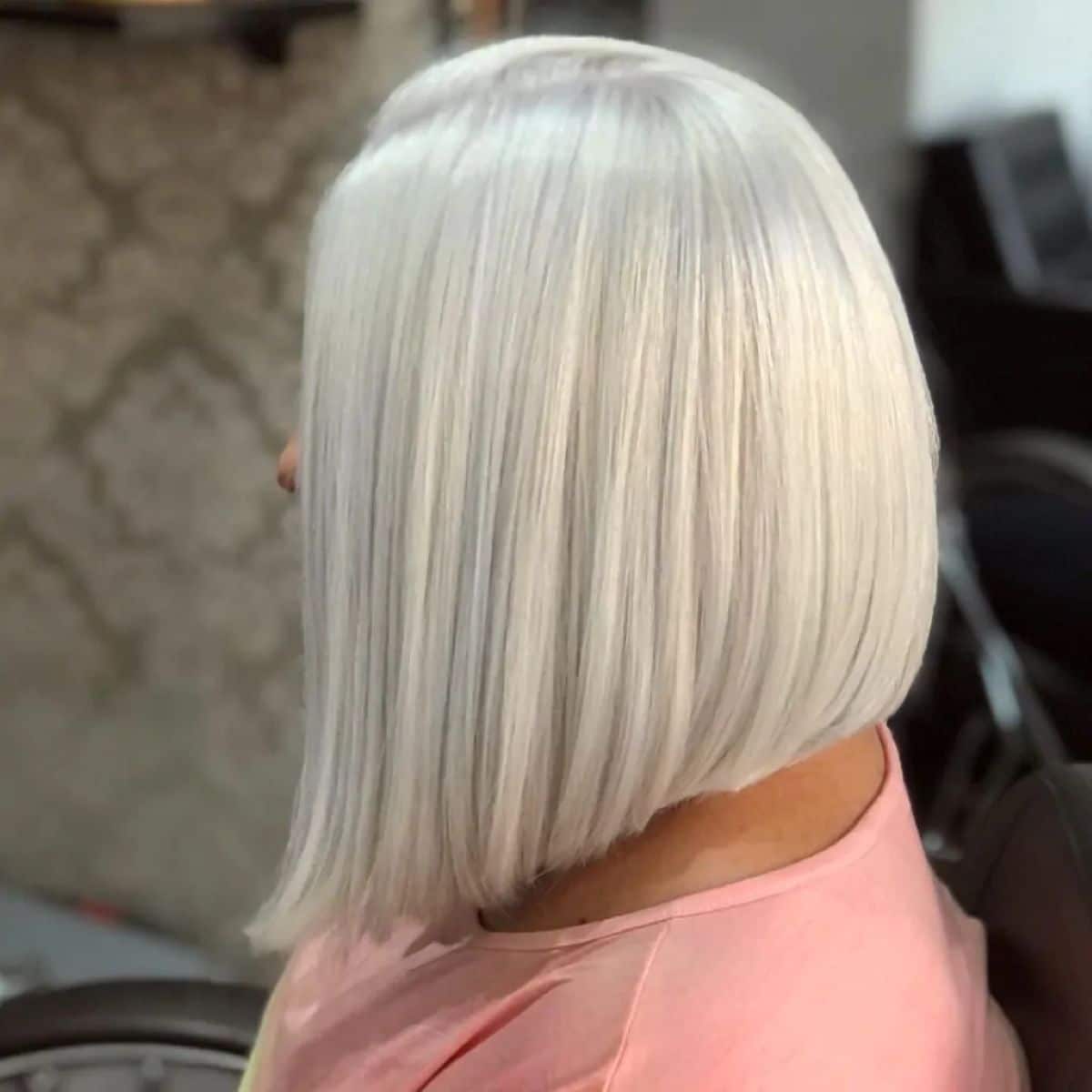 Cabelo médio platinado em corte Blunt Cut com base reta, moderno e elegante.