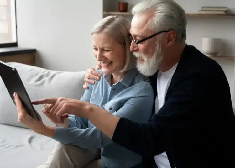 Casal de idosos explorando a tecnologia juntos, usando uma tablet para aprender com a inteligência artificial."