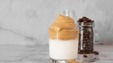 "Imagem de café cremoso com canela, servido em um copo com leite, destacando a camada cremosa de café por cima.