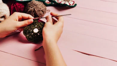 Mãos trabalhando com crochê, criando flores coloridas para decoração de primavera.