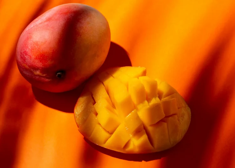 Manga fresca cortada, rica em fibras e antioxidantes, ideal para melhorar a saúde intestinal e proteger o coração.