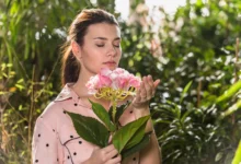 Mulher cheirando flores na primavera em um ambiente natural, simbolizando a leveza e renovação dessa estação.