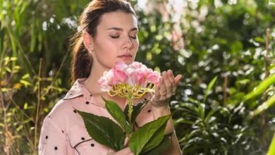 Mulher cheirando flores na primavera em um ambiente natural, simbolizando a leveza e renovação dessa estação.
