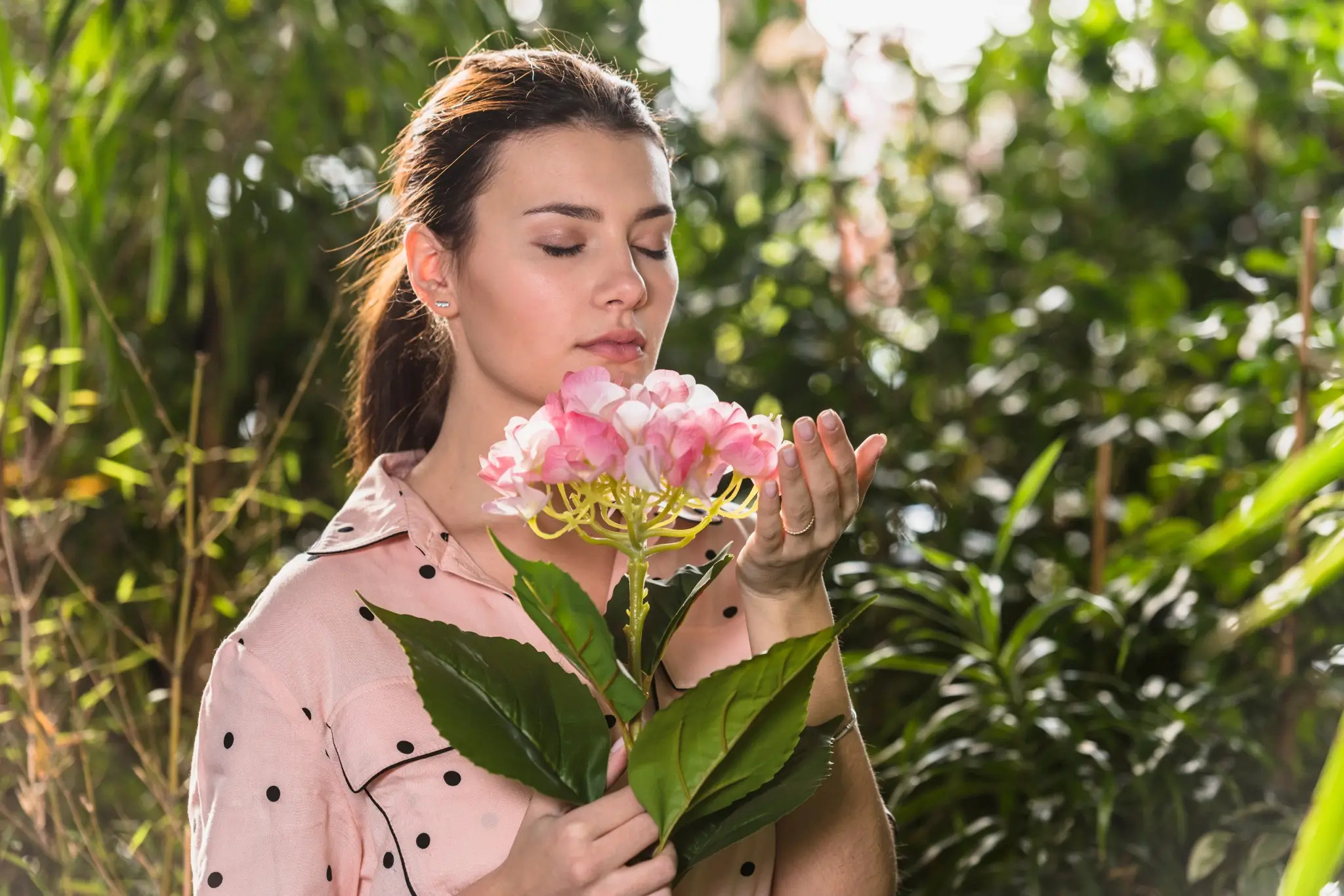 Mulher cheirando flores na primavera em um ambiente natural, simbolizando a leveza e renovação dessa estação.