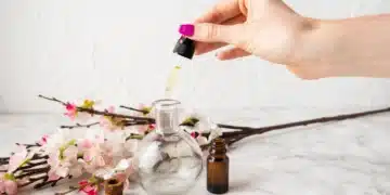 Mão segurando conta-gotas com óleo de rosa mosqueta.